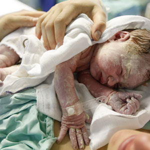 A sleeping newborn in an incubator, wrapped in a cozy blanket. Birth Trauma Claims. - Robichaux Law Firm, LLC.